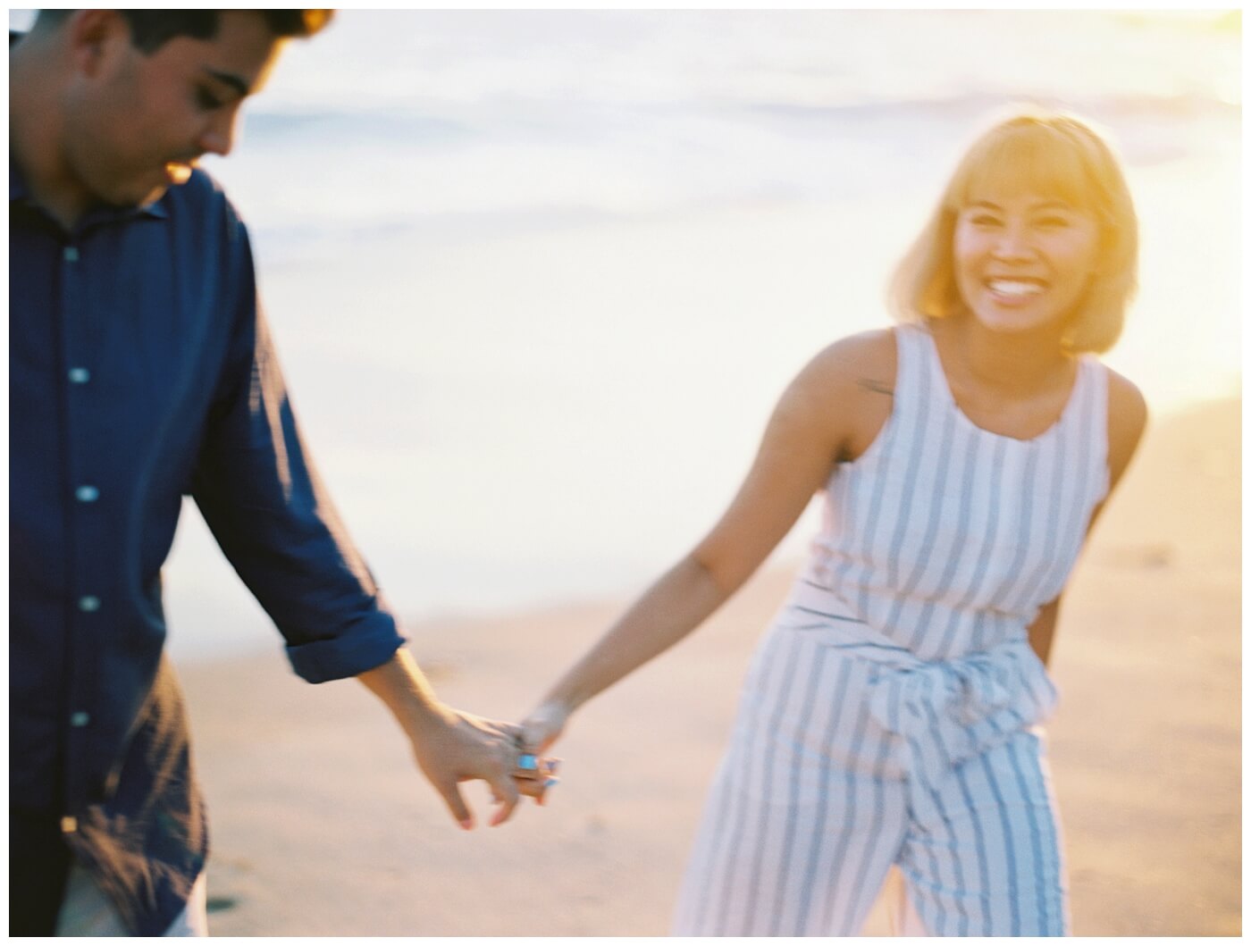 bride and groom holding hands during their engagement session wearing casual clothes and smiling
